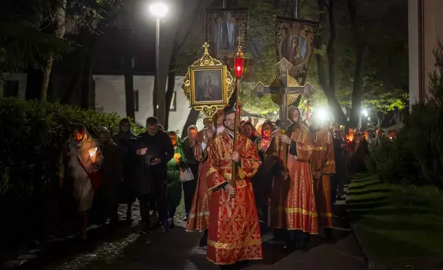 Lithuanian Orthodox priests walk in the Easter procession outside the Orthodox Church of the Holy Spirit in Vilnius, Lithuania, shortly after midnight, Sunday, April 20, 2025. (AP Photo/Mindaugas Kulbis)