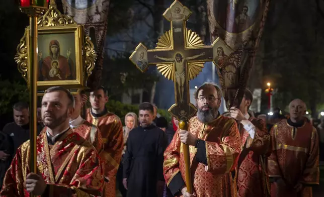 Lithuanian Orthodox priests walk in the Easter procession outside the Orthodox Church of the Holy Spirit in Vilnius, Lithuania, shortly after midnight, Sunday, April 20, 2025. (AP Photo/Mindaugas Kulbis)
