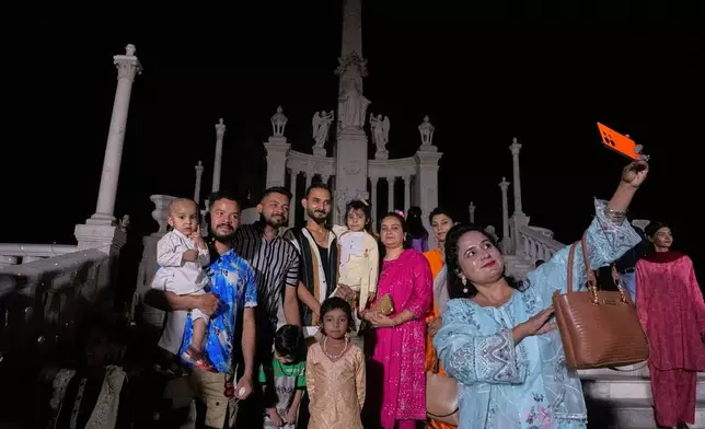 A Christian family take selfie after attending a midnight Easter Mass at St. Patrick's Cathedral Church, in Karachi, Pakistan, Sunday, April 20, 2025. (AP Photo/Fareed Khan)