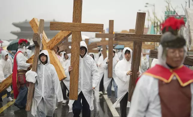 Participants holding crosses march in the rain during the Easter parade in Seoul, South Korea, Saturday, April 19, 2025. (AP Photo/Lee Jin-man)