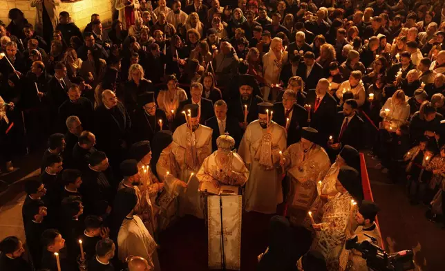 Ecumenical Patriarch Bartholomew I, center, the spiritual leader of the world's Eastern Orthodox Christians, stands as worshippers hold candles during Easter Vigil Mass on the eve of Christ's resurrection at the Patriarchal Church of St. George in Istanbul, Turkey, Sunday, April 20, 2025. (AP Photo/Khalil Hamra)