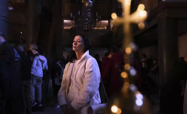 A woman attends the Orthodox Christians service of the Graveside Lamentation at the Patriarchal Church of St. George, in Istanbul, Turkey, Friday, April 18, 2025. (AP Photo/Francisco Seco)