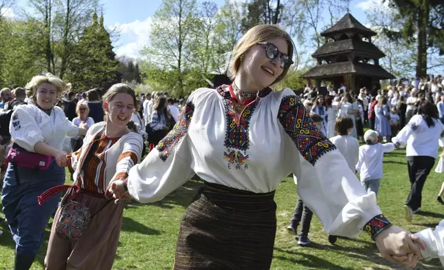 People in traditional Ukrainian clothes perform folk dances during celebrations for Orthodox Easter at the Museum of Folk Architecture and Life in Lviv, Ukraine, on Sunday, April 20, 2025. (AP Photo/Mykola Tys)