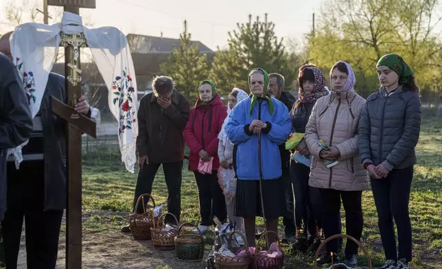 People stand in line to have their Easter baskets blessed during celebration of the Orthodox Easter in Krasne village, Ukraine, on Sunday, April 20, 2025. (AP Photo/Evgeniy Maloletka)
