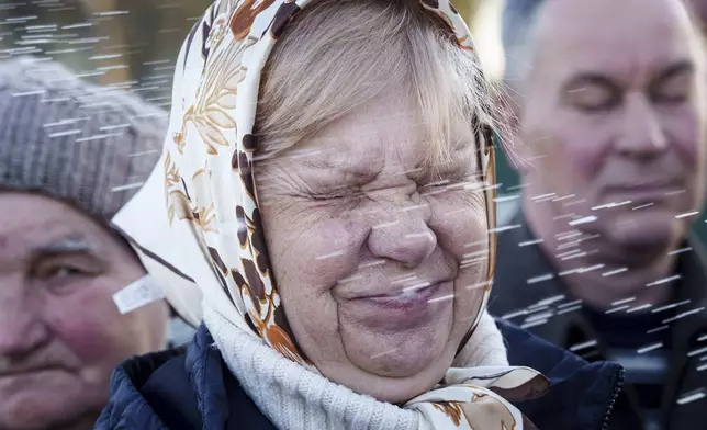 A women is blessed by a priest during celebration of the Orthodox Easter in Krasne village, Ukraine, on Sunday, April 20, 2025. (AP Photo/Evgeniy Maloletka)