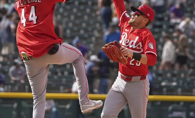 Cincinnati Reds shortstop Elly De La Cruz, left, celebrates with center fielder TJ Friedl, right, after defeating the Colorado Rockies in a baseball game Saturday, April 26, 2025, in Denver. (AP Photo/David Zalubowski)