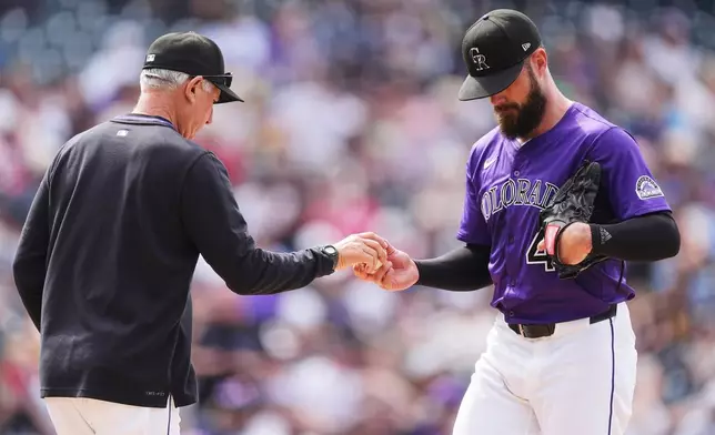 Colorado Rockies manager Bud Black, left, takes the ball from relief pitcher Tyler Kinley as he is pulled form the mound after giving up an RBI single to Cincinnati Reds' Spencer Steer in the ninth inning of a baseball game Saturday, April 26, 2025, in Denver. (AP Photo/David Zalubowski)