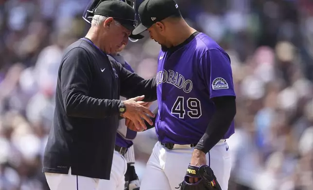 Colorado Rockies manager Bud Black, left, takes the ball from starting pitcher Antonio Senzatela as he is pulled form the mound after giving up a single to Cincinnati Reds' Gavin Lux in the sixth inning of a baseball game Saturday, April 26, 2025, in Denver. (AP Photo/David Zalubowski)