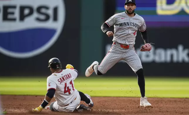 Cleveland Guardians' Carlos Santana (41) is forced out at second base by Minnesota Twins shortstop Carlos Correa (4) in the second inning of a baseball game in Cleveland, Monday, April 28, 2025. (AP Photo/Sue Ogrocki)