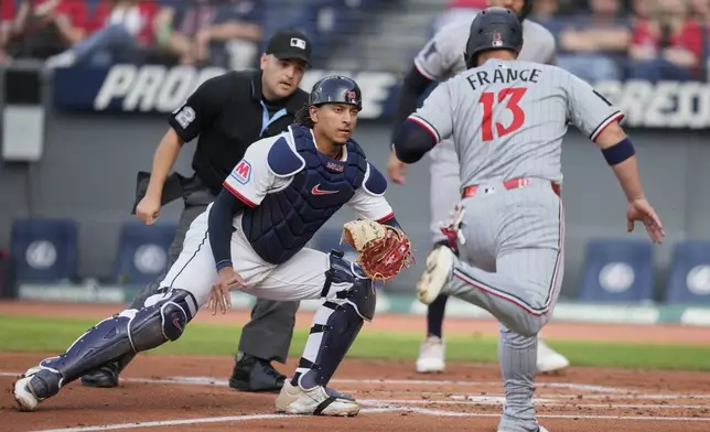 Cleveland Guardians catcher Bo Naylor prepares to tag out Minnesota Twins' Ty France (13) at home plate in the first inning of a baseball game in Cleveland, Monday, April 28, 2025. (AP Photo/Sue Ogrocki)