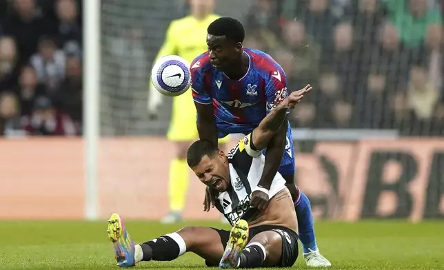 Newcastle United's Bruno Guimaraes, below, and Crystal Palace's Marc Guehi battle for the ball during the English Premier League soccer match between Newcastle United and Crystal Palace at St. James' Park, Newcastle upon Tyne, England, Wednesday, April 16, 2025. (Owen Humphreys/PA via AP)