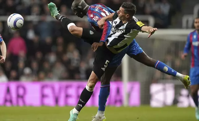 Newcastle United's Fabian Schar, front, and Crystal Palace's Jean-Philippe Mateta battle for the ball during the English Premier League soccer match between Newcastle United and Crystal Palace at St. James' Park, Newcastle upon Tyne, England, Wednesday, April 16, 2025. (Owen Humphreys/PA via AP)