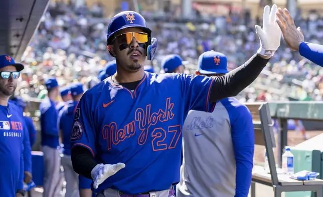 New York Mets' Mark Vientos (27) celebrates in the dugout after scoring during the seventh inning of a baseball game against the Athletics Sunday, April 13, 2025, in West Sacramento, Calif. (AP Photo/Sara Nevis)