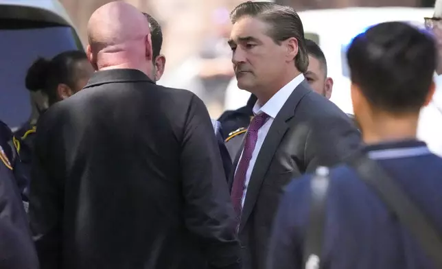 Harris County District Attorney Sean Teare stands with local law enforcement officials as officers investigate the scene where a Pct. 1 Constable's deputy and a suspect was shot near a courthouse complex in Houston, Monday, April 21, 2025. (Brett Coomer/Houston Chronicle via AP)