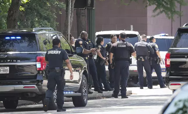 Law enforcement stand outside the Family Law Center at San Jacinto and Franklin after a Harris County deputy was shot in Houston, Monday, April 21, 2025. (Yi-Chin Lee/Houston Chronicle via AP)