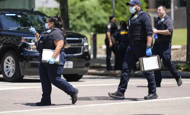Law enforcement officers investigate the scene where a Texas sheriff's deputy and a suspect were shot outside the Family Law Center in Houston, Monday, April 21, 2025. (Brett Coomer/Houston Chronicle via AP)