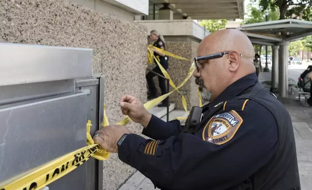 Law enforcement work outside the family courthouse at San Jacinto and Franklin after a Harris County sheriff's deputy was shot, as was the suspected shooter, in Houston, Monday, April 21, 2025. (Yi-Chin Lee/Houston Chronicle via AP)