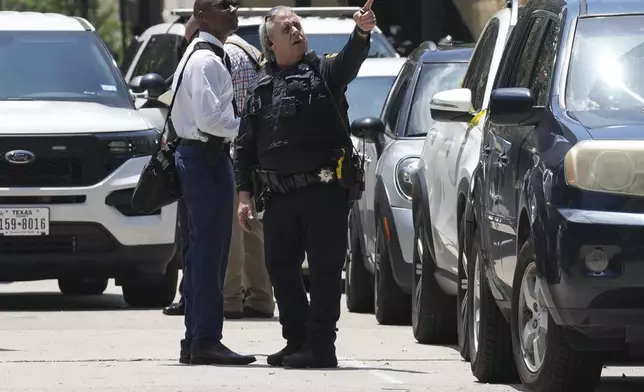 Investigators talk to law enforcement officers outside the Family Law Center at San Jacinto and Franklin after a Harris County deputy was shot, as was the suspected shooter, in Houston, Monday, April 21, 2025. (Yi-Chin Lee/Houston Chronicle via AP)