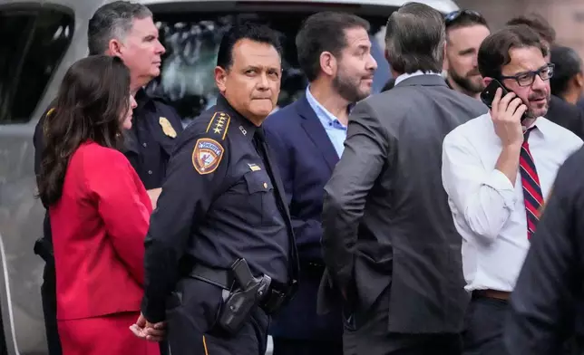Harris County Sheriff Ed Gonzalez stands with local officials as law enforcement officers investigate the scene where a Harris County deputy and a suspect were shot outside the Family Law Center in Houston, Monday, April 21, 2025. (Brett Coomer/Houston Chronicle via AP)