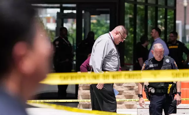 Law enforcement officers investigate the scene where a Texas deputy and a suspect were shot outside the Family Law Center in Houston, Monday, April 21, 2025. (Brett Coomer/Houston Chronicle via AP)