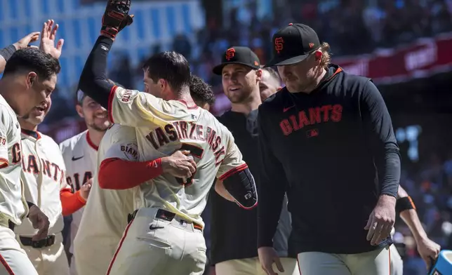 The San Francisco Giants celebrate a home run by Mike Yastrzemski (5) during the tenth inning of a baseball game to beat the Cincinnati Reds in San Francisco, Wednesday, April 9, 2025. (AP Photo/Nic Coury)