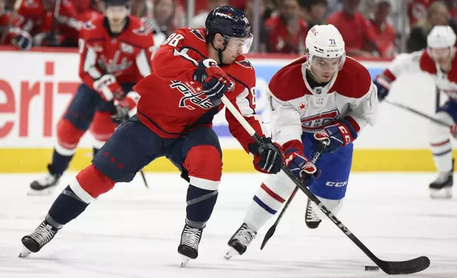 Washington Capitals left wing Andrew Mangiapane (88) and Montreal Canadiens center Jake Evans (71) battle for the puck in the first period of Game 1 of a first-round NHL hockey playoff series Monday, April 21, 2025, in Washington. (AP Photo/Nick Wass)