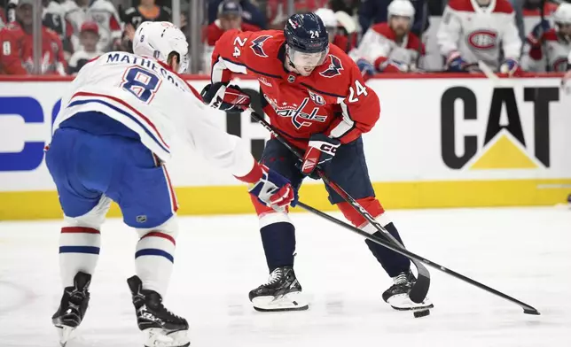 Washington Capitals center Connor McMichael (24) and Montreal Canadiens defenseman Mike Matheson (8) battle for the puck in the first period of Game 1 of a first-round NHL hockey playoff series Monday, April 21, 2025, in Washington. (AP Photo/Nick Wass)