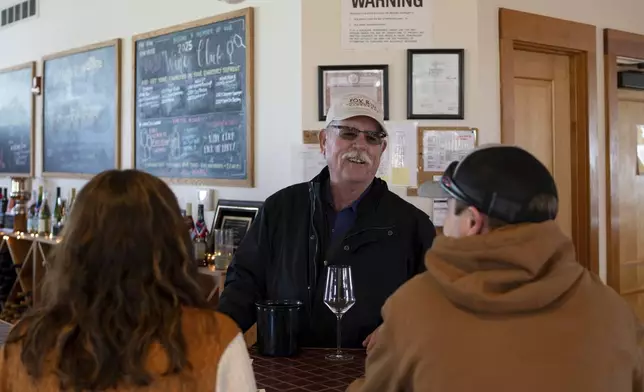 Scott Osborn, owner of Fox Run Vineyards, chats with customers Friday, March 21, 2025, in Penn Yan, N.Y. (Natasha Kaiser via AP)