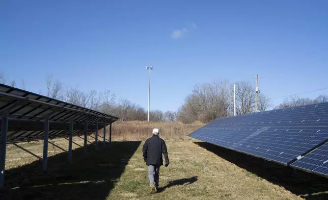 Scott Osborn, owner of Fox Run Vineyards, walks through the vineyards past solar panels Friday, March 21, 2025, in Penn Yan, N.Y. (Natasha Kaiser via AP)