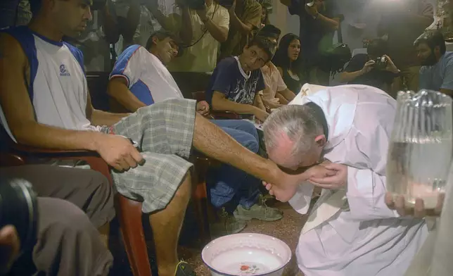 FILE - Argentina's cardinal Jorge Mario Bergoglio, right, kisses the foot of Cristian Marcelo Reynoso during a Mass with youth trying to overcome drug addictions in Buenos Aires, Argentina, Thursday, March 20, 2008. (AP Photo)