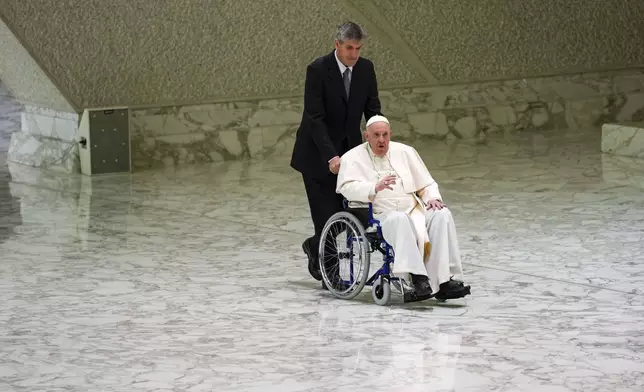 FILE - Pope Francis arrives in a wheelchair to attend an audience with nuns and religious superiors in the Paul VI Hall at The Vatican, Thursday, May 5, 2022. (AP Photo/Alessandra Tarantino, File)