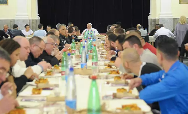 FILE - Pope Francis, center, eats with inmates in Naples' 'Poggioreale' prison, Italy, Saturday, March 21, 2015. (AP Photo/L'Osservatore Romano, Pool, File)