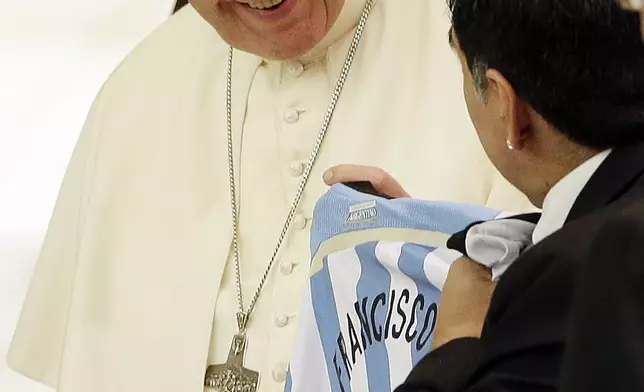 FILE - Diego Armando Maradona presents Pope Francis with an Argentine national soccer team jersey bearing the name Francisco on it, in the Paul VI hall at the Vatican, Monday, Sept. 1, 2014 ahead of an interreligious match for peace. (AP Photo/Gregorio Borgia, File)