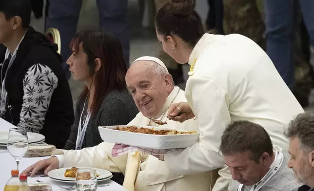 FILE - Pope Francis sits at a table during a lunch with homeless, migrants, unemployed and poor people, in the Paul VI Hall at the Vatican, Sunday, Nov. 17, 2019. (AP Photo/Alessandra Tarantino, File)