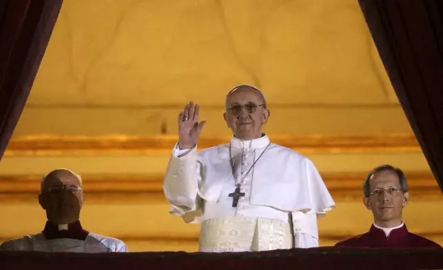 FILE - Argentine Cardinal Jorge Bergoglio, who chose the name of Pope Francis, waves to the crowd from the central balcony of St. Peter's Basilica after being elected 266th pontiff of the Roman Catholic Church, at the Vatican, Wednesday, March 13, 2013. (AP Photo/Gregorio Borgia, file)