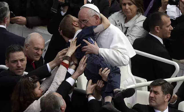 FILE - Pope Francis hugs 8-year-old Dominic Gondreau, who has cerebral palsy, after celebrating his first Easter Mass in St. Peter's Square at the Vatican. Sunday, March 31, 2013. (AP Photo/Gregorio Borgia, File)