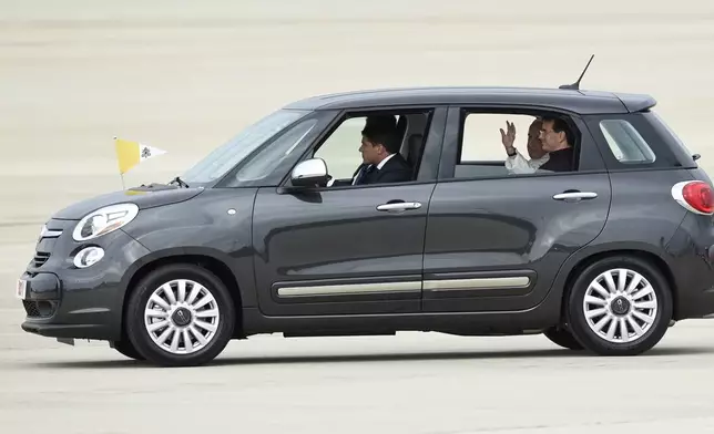 FILE - Pope Francis waves from inside a Fiat 500 as he departs Andrews Air Force Base in Md, Tuesday, Sept. 22, 2015. (AP Photo/Susan Walsh, File)