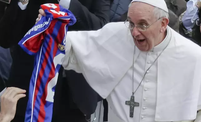 FILE - Pope Francis holds a San Lorenzo's jersey, the Buenos Aires soccer team, handed to him by a faithful at the end of the Easter mass in St. Peter's Square at the Vatican, Sunday, March 31, 2013. (AP Photo/Gregorio Borgia, File)