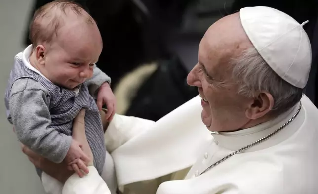 FILE - Pope Francis holds a baby during an audience with members of Entrepreneurs for Economy of Communion, at the Paul VI Hall, at the Vatican, Saturday, Feb. 4, 2017. (AP Photo/Andrew Medichini, File)