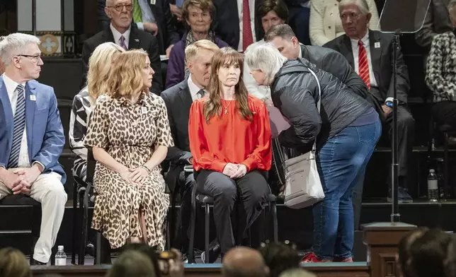 A woman gets onto the stage to speak to U.S. Senator James Lankford before being escorted away during the 30th anniversary memorial service for the victims of the 1995 Oklahoma City bombing, in Oklahoma City, Saturday, April 19, 2025. (AP Photo/Alonzo Adams)