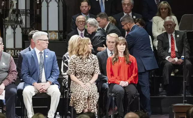 A woman is escorted away after getting onto the stage to speak to U.S. Senator James Lankford during the 30th anniversary memorial service for the victims of the 1995 Oklahoma City bombing, in Oklahoma City, Saturday, April 19, 2025. (AP Photo/Alonzo Adams)