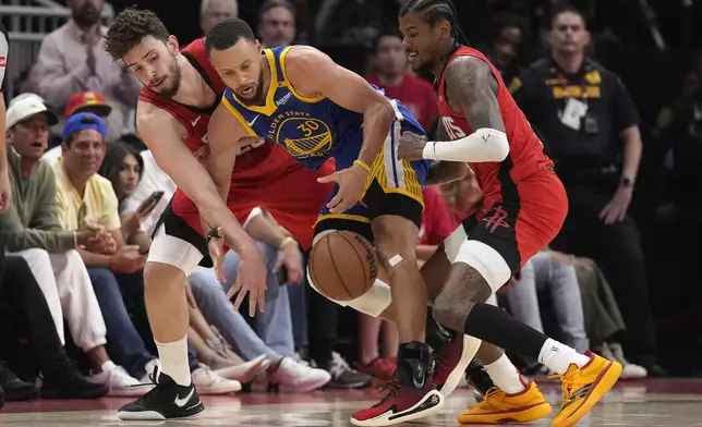 Golden State Warriors guard Stephen Curry, center, battles for a loose ball against Houston Rockets center Alperen Sengun, left, and, Rockets guard Jalen Green, right during the first half of Game 2 of an NBA basketball first-round playoff series against the Houston Rockets in Houston, Wednesday, April 23, 2025. (AP Photo/Karen Warren)