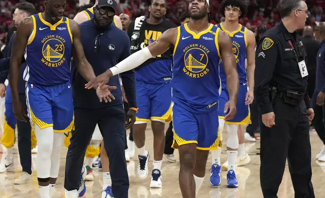 Golden State Warriors forward Draymond Green (23) is escorted back to the bench by a coach and guard Buddy Hield (7) after a brief scuffle with the Houston Rockets during the second half of Game 2 of an NBA basketball first-round playoff series against the Houston Rockets in Houston, Wednesday, April 23, 2025. (AP Photo/Karen Warren)