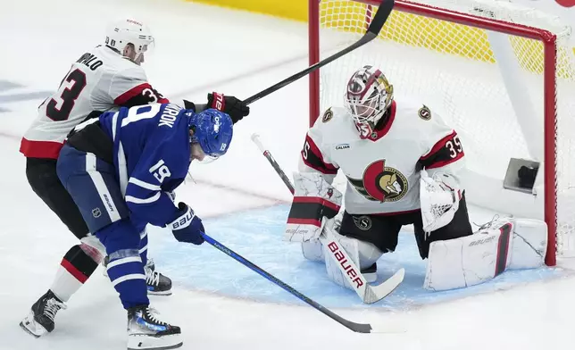 Ottawa Senators goaltender Linus Ullmark (35) keeps a close eye on Toronto Maple Leafs' Calle Jarnkrok (19) as Nikolas Matinpalo (33) battles for the puck during the second period of an NHL hockey playoff game in Toronto on Tuesday, April 29, 2025. (Nathan Denette/The Canadian Press via AP)