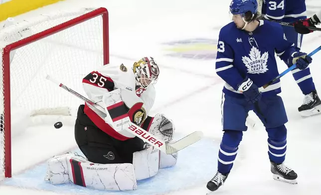Toronto Maple Leafs' Matthew Knies (23) tries to screen Ottawa Senators goaltender Linus Ullmark (35) during the first period of an NHL hockey playoff series in Toronto on Tuesday, April 29, 2025. (Nathan Denette/The Canadian Press via AP)