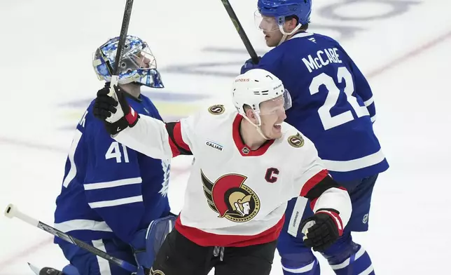 Ottawa Senators' Brady Tkachuk (7) celebrates his teammates' goal against Toronto Maple Leafs goaltender Anthony Stolarz (41) as Jake McCabe (22) looks on during the second period of an NHL hockey playoff game in Toronto on Tuesday, April 29, 2025. (Nathan Denette/The Canadian Press via AP)