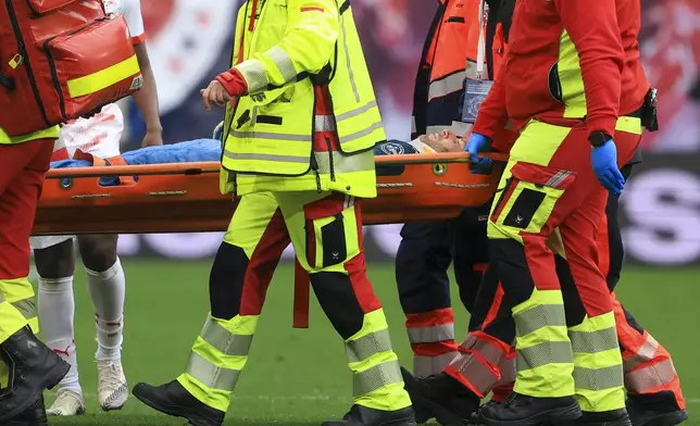 Leipzig goalkeeper Peter Gulacsi is carried off the pitch during the German Bundesliga soccer match between RB Leipzig and Holstein Kiel, at the Red Bull Arena in Leipzig, Germany, Saturday, April 19, 2025. (Jan Woitas/dpa via AP)