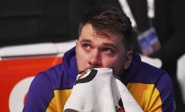 Los Angeles Lakers' Luka Doncic becomes emotional as he watches a video on the large video board that was a tribute to the former Dallas Mavericks player before an NBA basketball game in Dallas, Wednesday, April 9, 2025. (AP Photo/LM Otero)