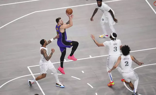 Los Angeles Lakers guard Luka Doncic shoots over Dallas Mavericks' Anthony Davis (3) and Dereck Lively II (2) in the first half of an NBA basketball game in Dallas, Wednesday, April 9, 2025. (AP Photo/Julio Cortez)