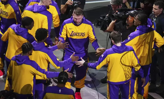 Los Angeles Lakers' Luka Doncic greets teammate during introductions before an NBA basketball game against the Dallas Mavericks in Dallas, Wednesday, April 9, 2025. (AP Photo/Julio Cortez)
